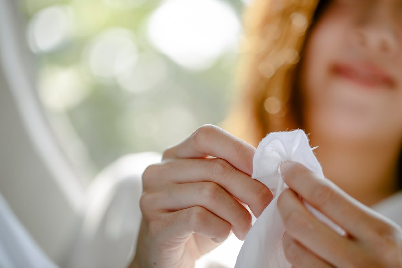 services-01 Focused shot of a woman delicately sewing white fabric by hand.